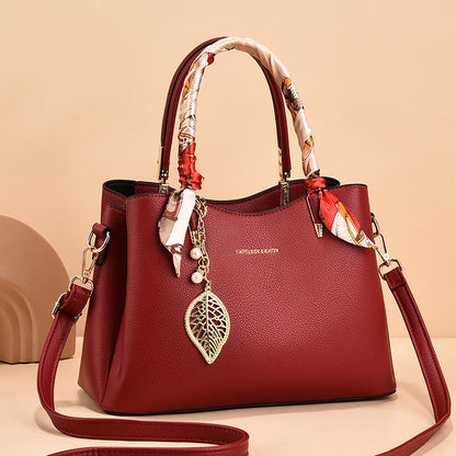Leather Shoulder Bag with Scarf-Wrapped Handles and Gold Leaf Charm