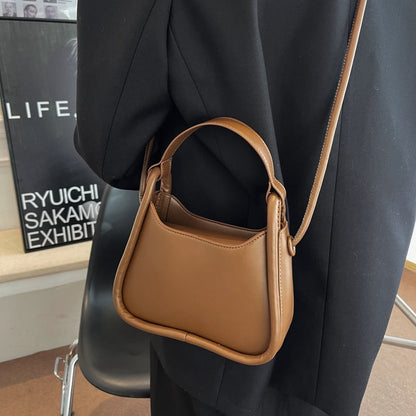 Sleek Black Leather Shoulder Bag with Curved Base