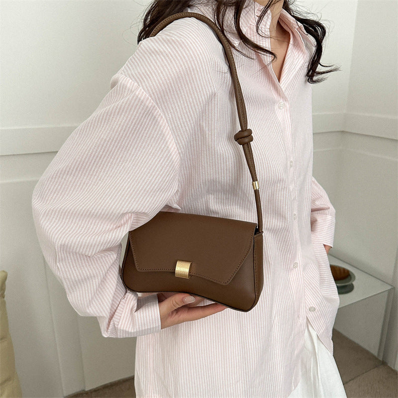 Sleek Leather Shoulder Bag with Gold Clasp and Knot Strap