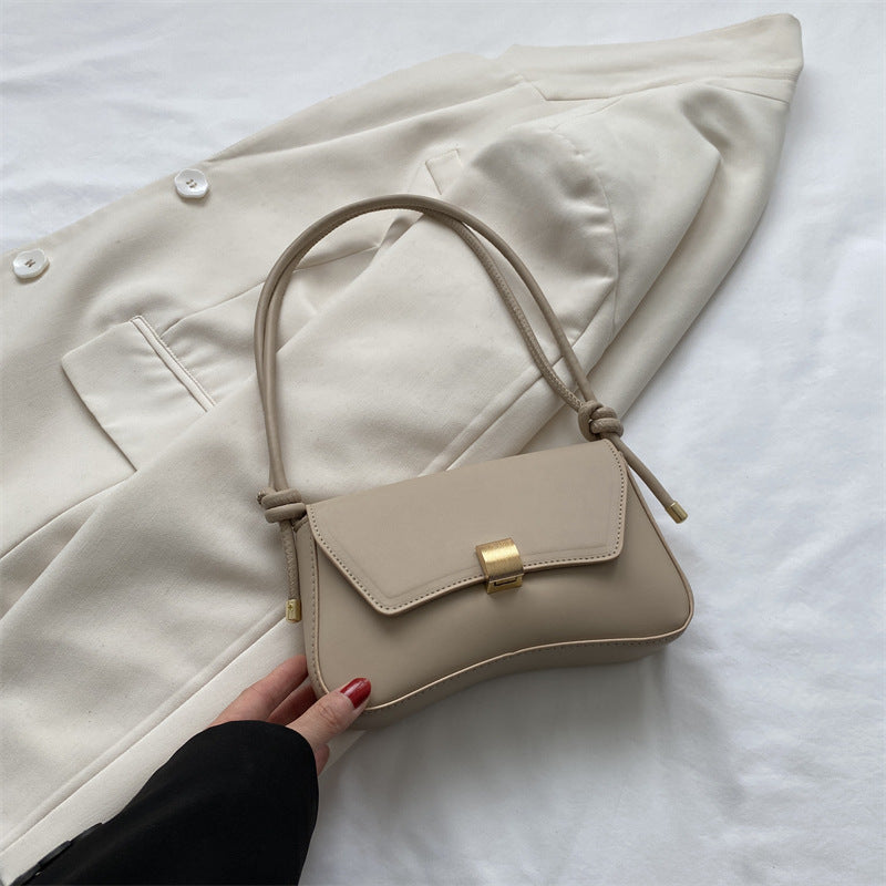 Sleek Leather Shoulder Bag with Gold Clasp and Knot Strap
