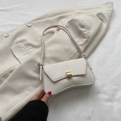 Sleek Leather Shoulder Bag with Gold Clasp and Knot Strap