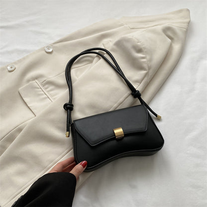 Sleek Leather Shoulder Bag with Gold Clasp and Knot Strap
